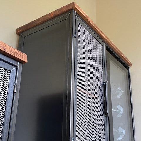 coffee station metal storage cabinet with perforated mesh doors and a rustic wood top, shown against a beige wall.